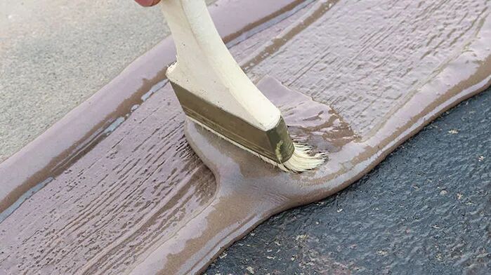 Brushing primer onto the substrate of an SBS waterproofing membrane roof